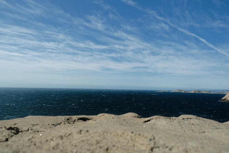 the sky is mostly blue, but the water and sand is dark