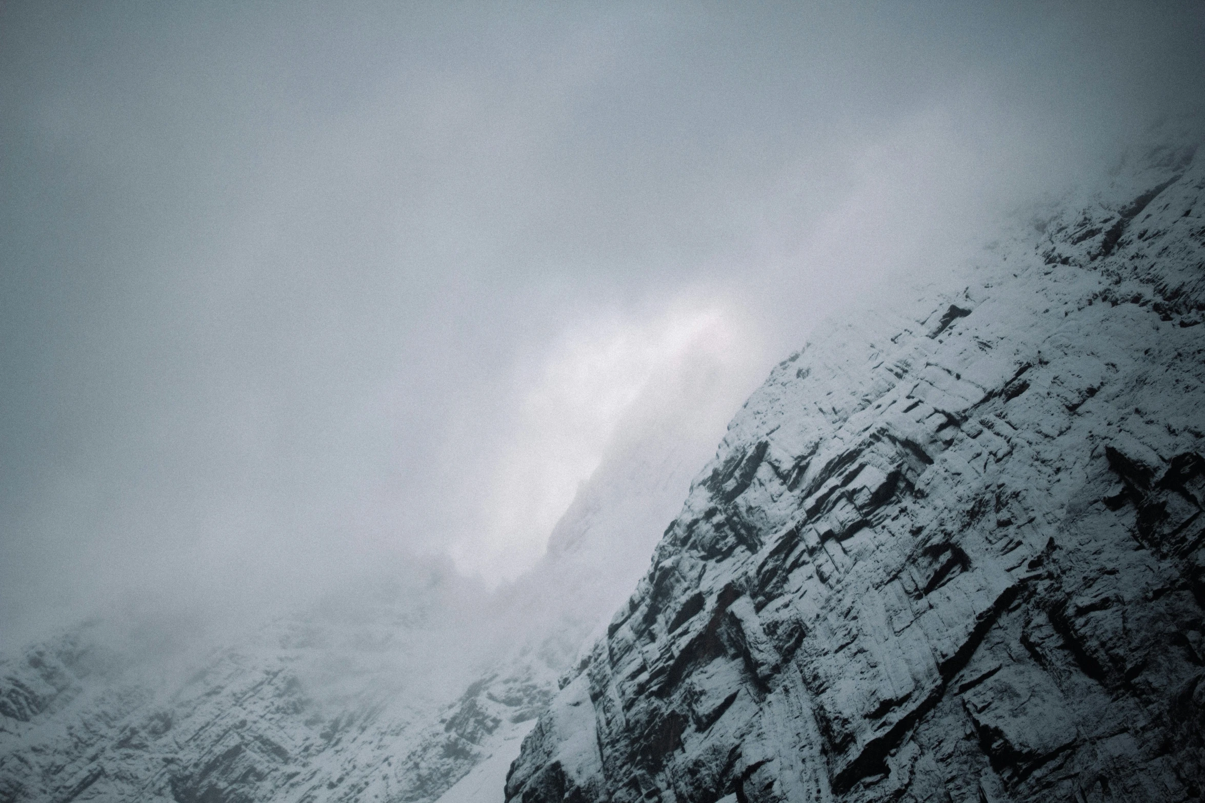 snow capped mountains under a gray sky with clouds