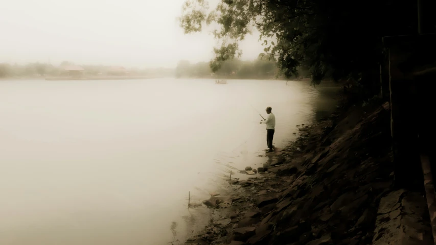 a person standing on the side of a lake next to water