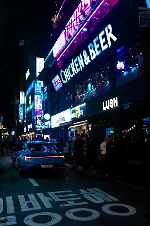 the street is lined with bright neon lights and advertits