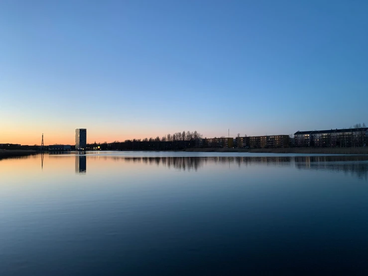 a lake and a building at dusk with a reflection in the water
