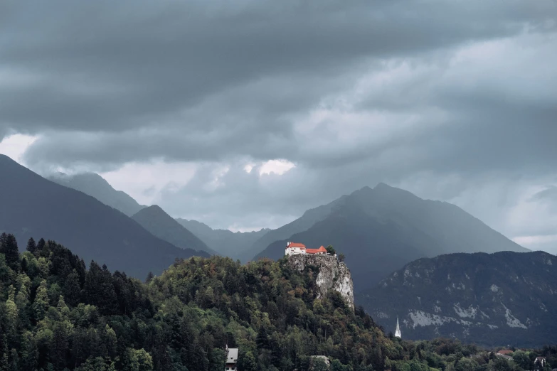 an old castle is in the distance as dark clouds are hovering