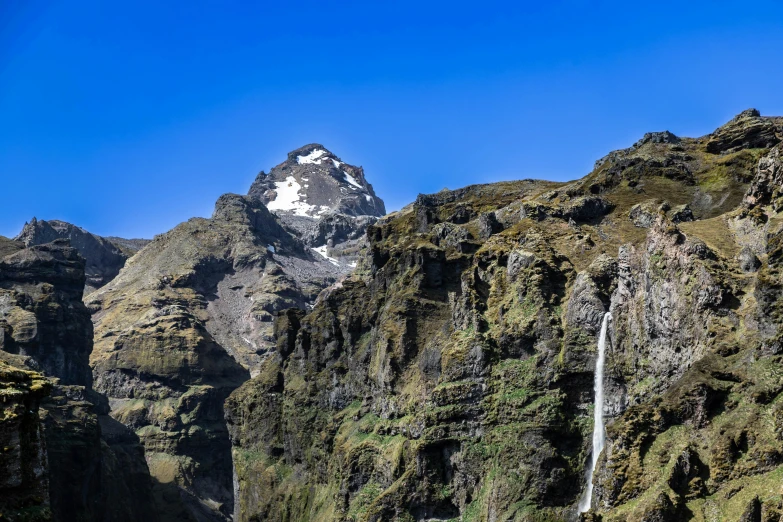 a very tall mountain with a waterfall running from it