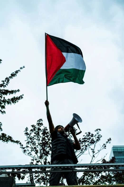 a man is waving a flag while holding a megaphone