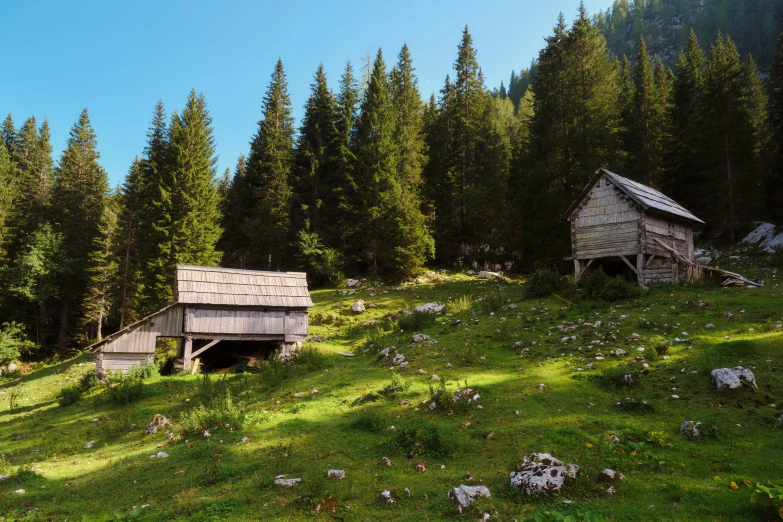 old dilapidated building sitting in the grass on a hillside