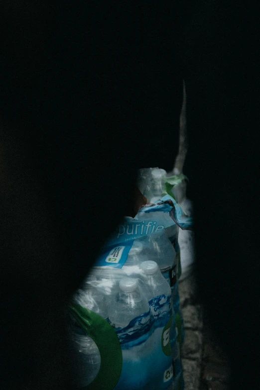 a bottle of water sitting in the darkness