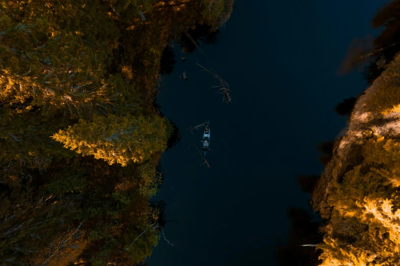 an aerial view of a boat floating down the river at night