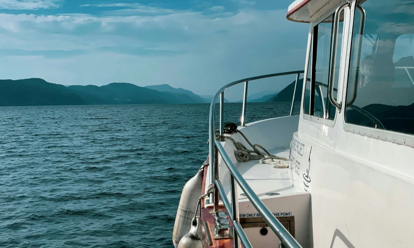 a boat that is on the water with mountains in the background