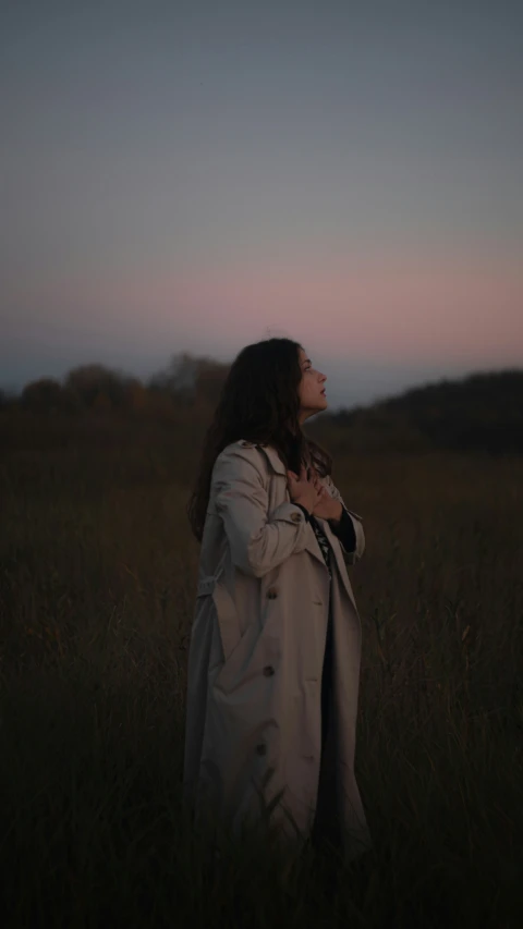 a woman standing in a field with her back to the camera