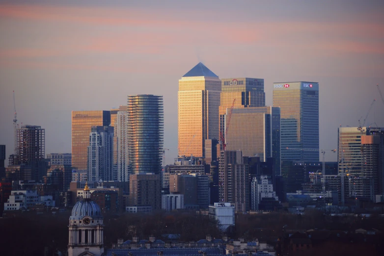 the skyline of large city buildings and towers is pictured at twilight