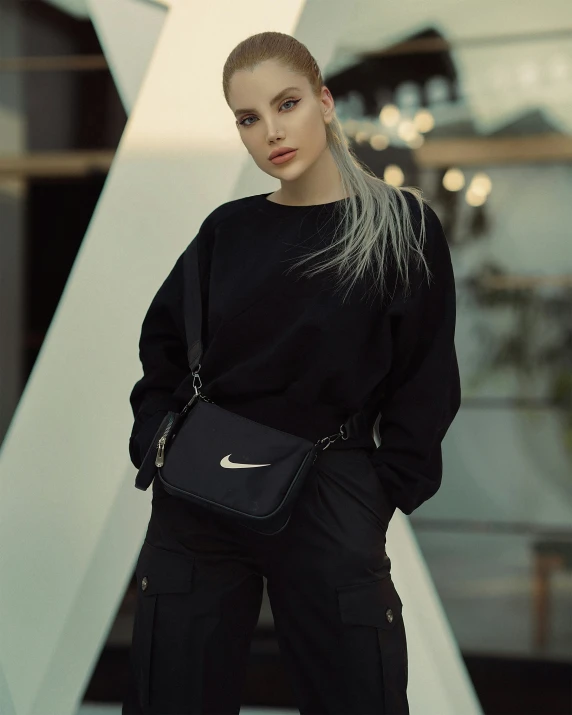the blonde haired girl poses with a black purse