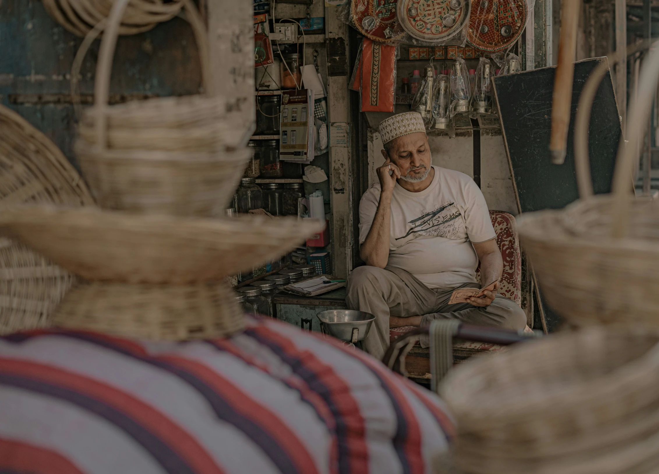 there is a man sitting in front of many baskets