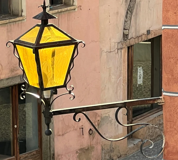 an illuminated light outside a window, with pink buildings