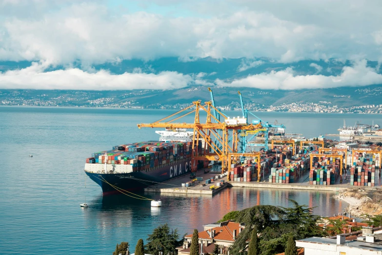 a large cargo ship in the ocean under a cloudy sky