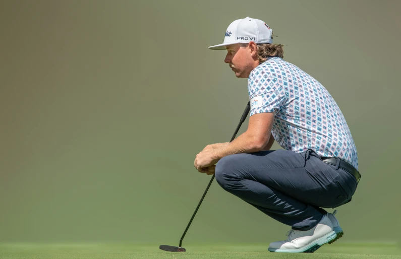 a man bending over while holding a golf club