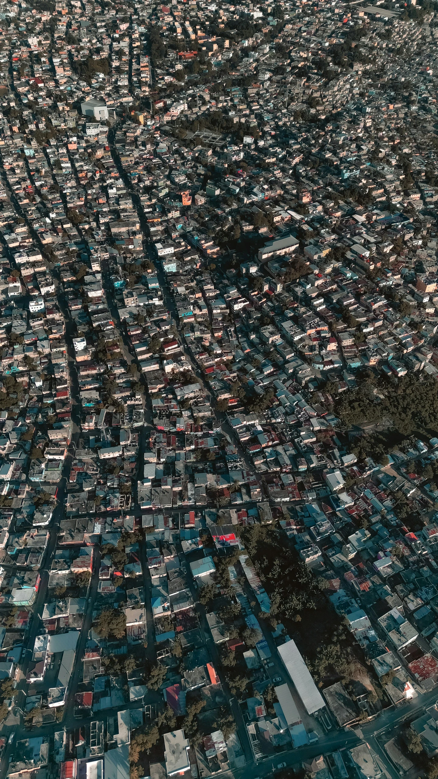 an airplane wing flying over a bunch of buildings