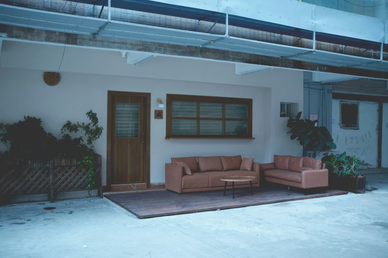 a room with brown couches on an outdoor rug