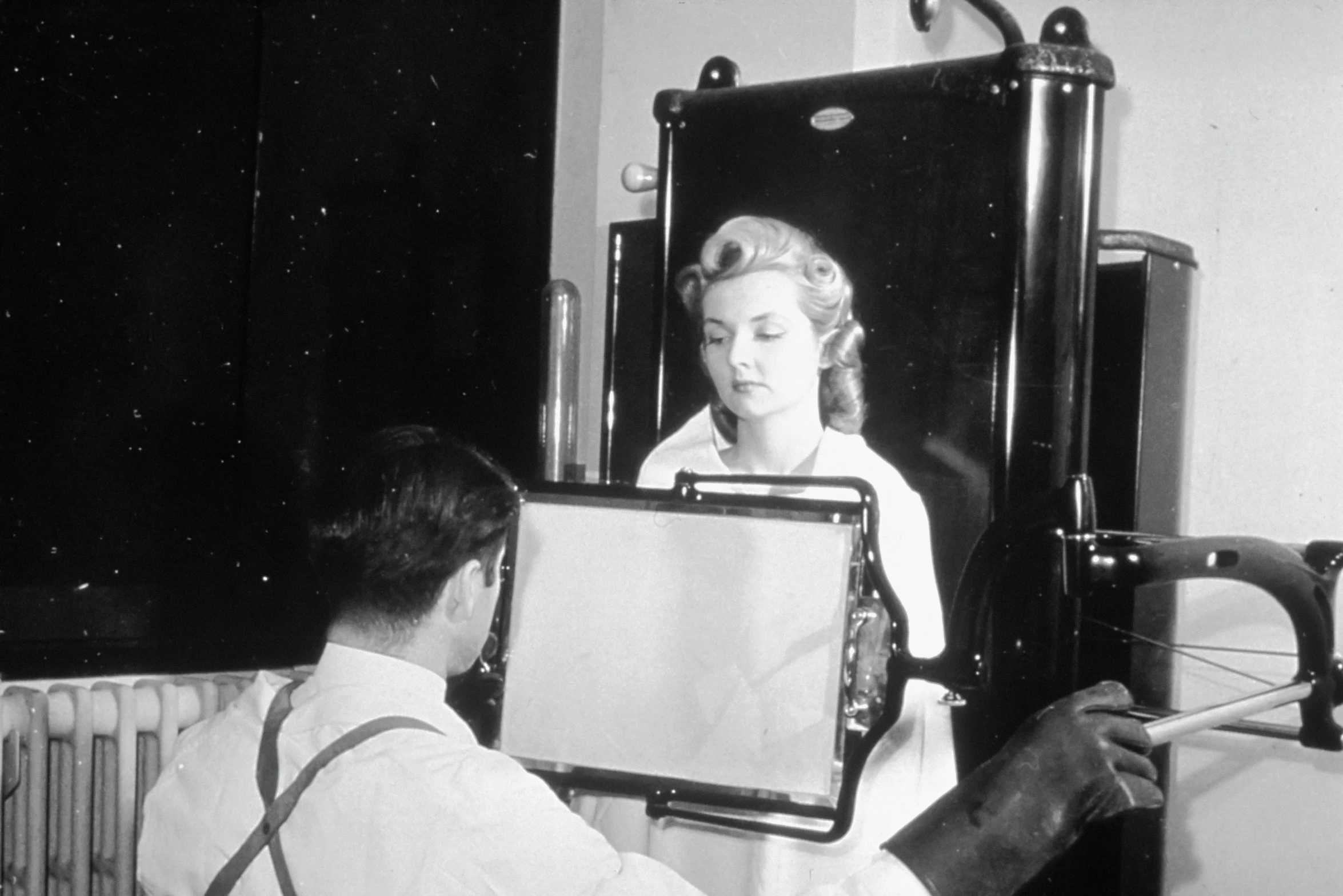 a black and white image of a man taking a pograph of a woman