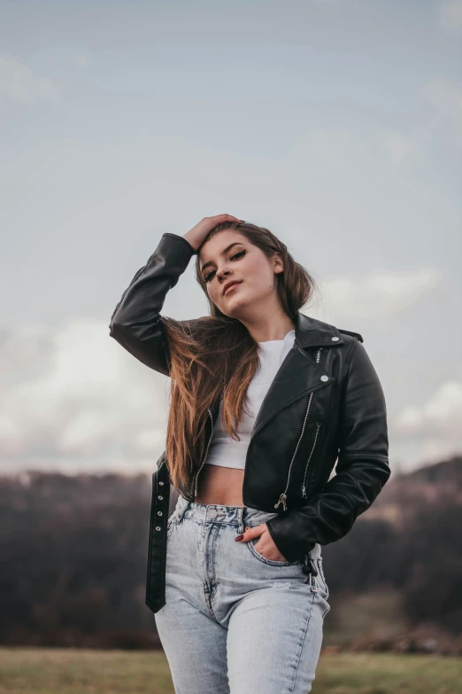 a woman in a leather jacket is posing for the camera