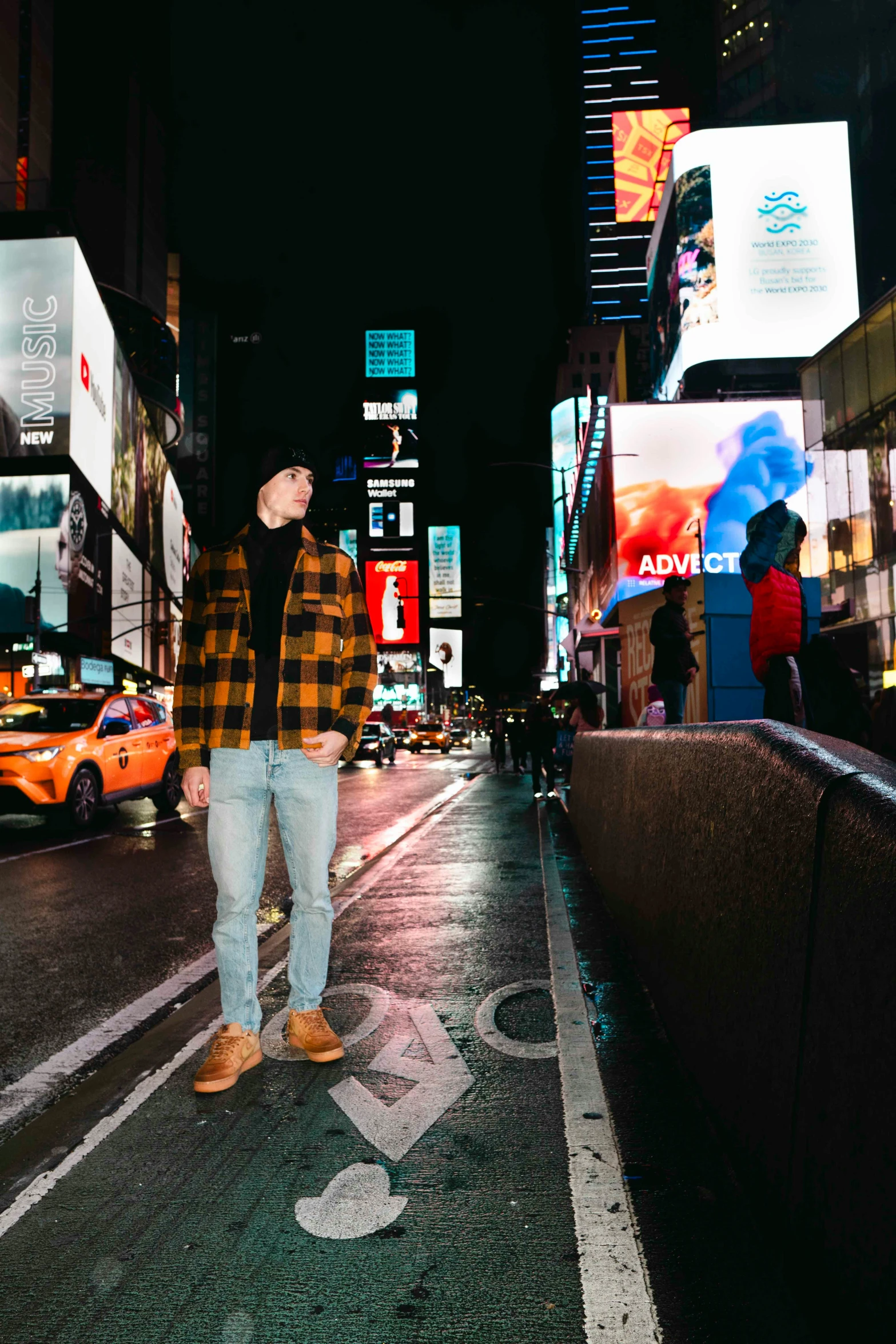 there is a man standing on the street at night