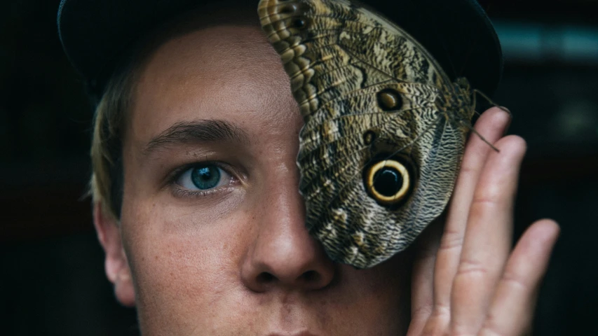 a person holding a large brown bird on top of their head