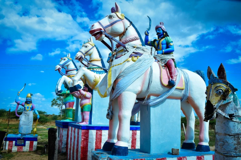 an outdoor carousel with painted horses and people