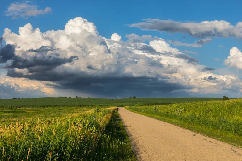 the sky is filled with clouds over a field