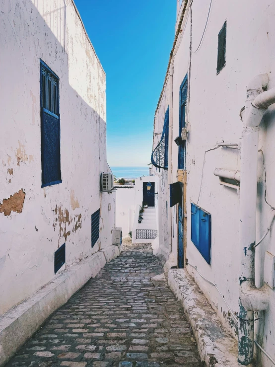 a stone street with several windows and shutters