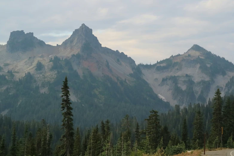 a road passing by a mountain range with trees