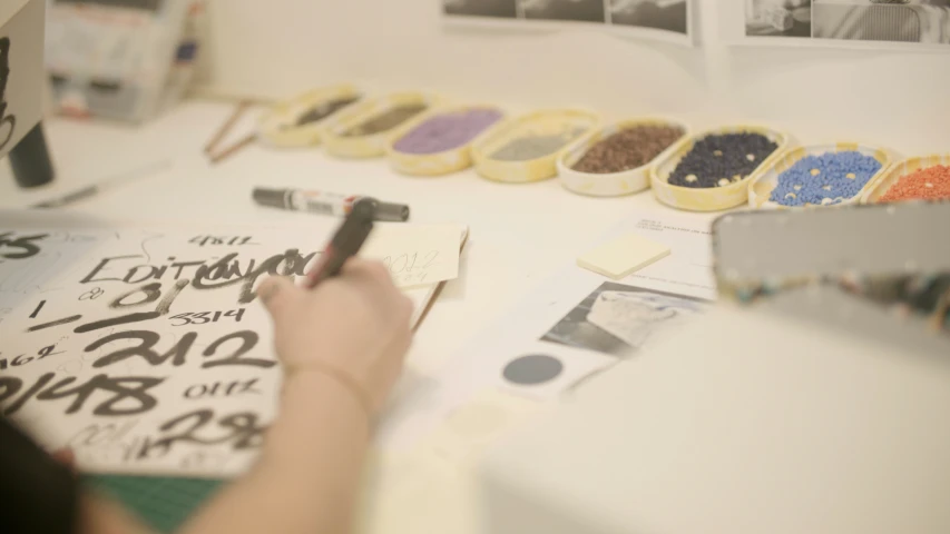 person working on an article on a desk with many pictures