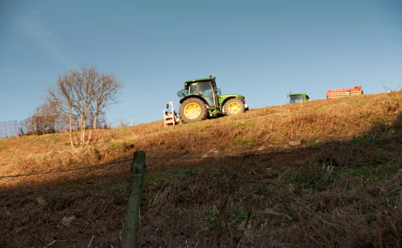 a tractor sitting on top of a grassy hillside