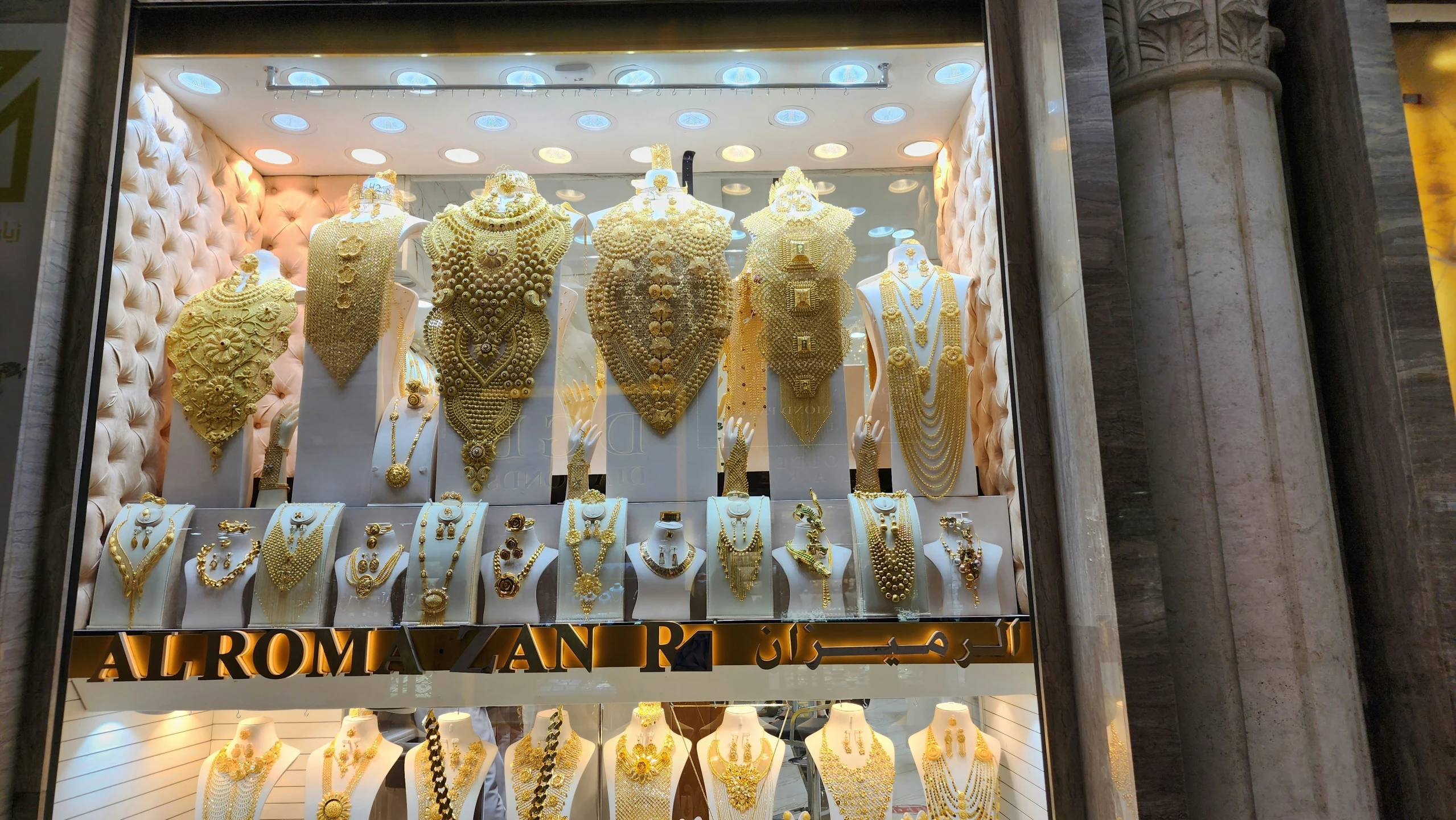 several necklaces are on display behind glass at the store