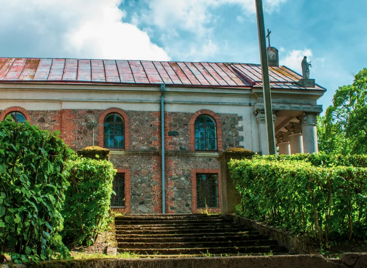 an old building has many windows and ivy covered steps