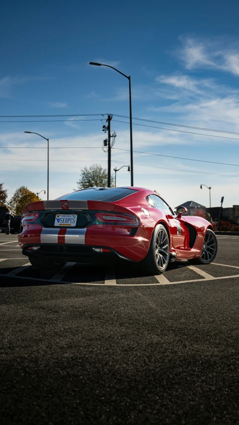 an image of a red sports car sitting in the parking lot