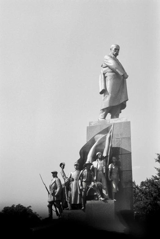 a group of people standing next to a large statue