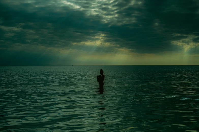 a person is standing in water with a dark sky in the background