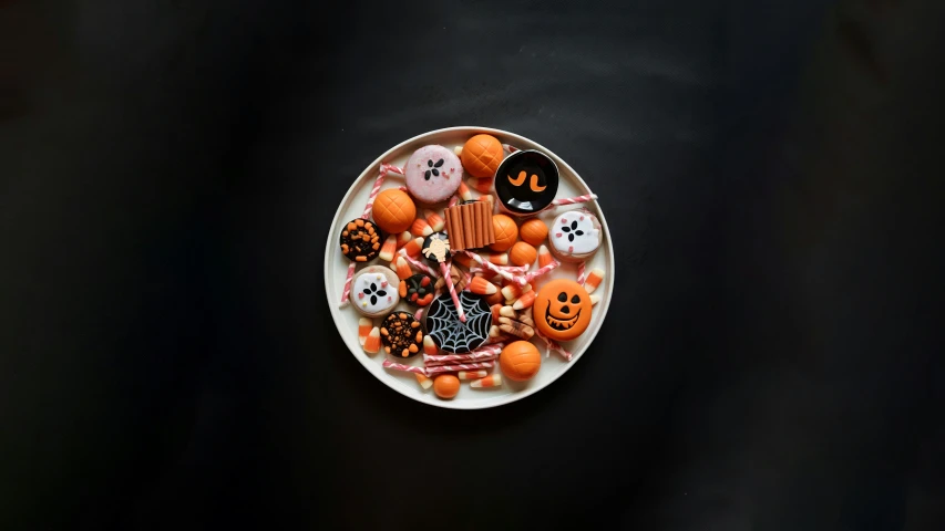 an artistic looking plate of halloween cookies with jack - o'lanterns on it