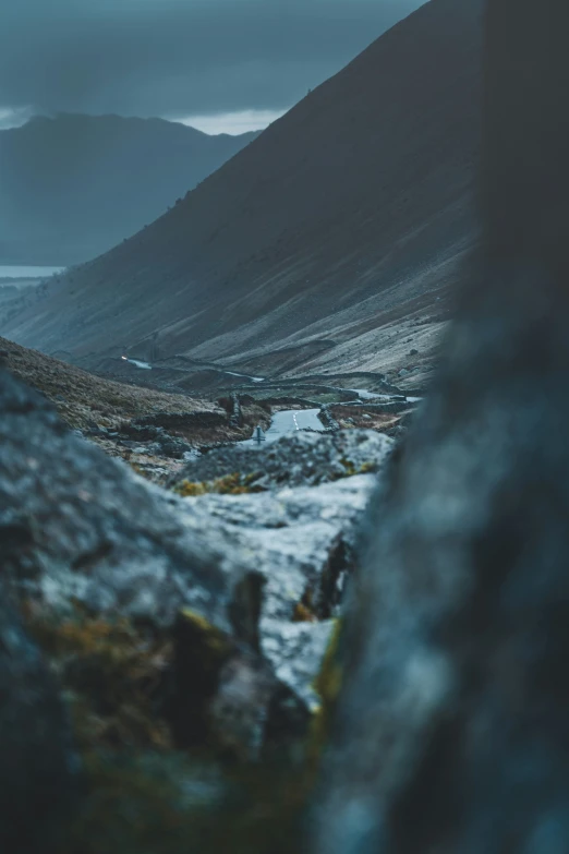 a mountain scene with water and a couple of hills