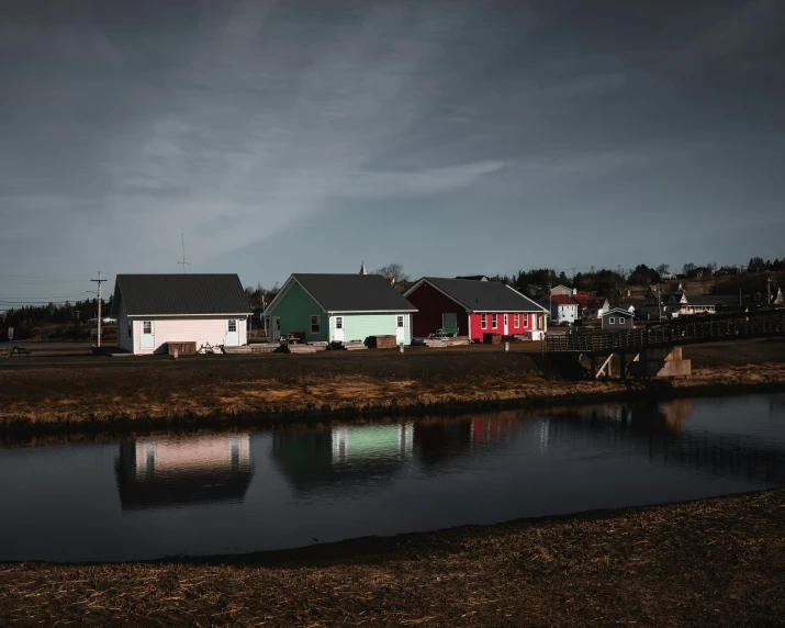 a row of colorful houses next to water on a hill