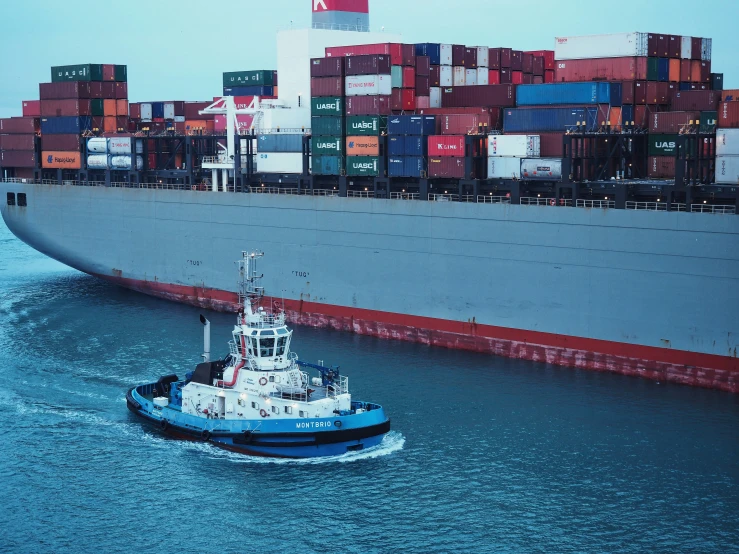 a boat sailing on the ocean near a large container ship