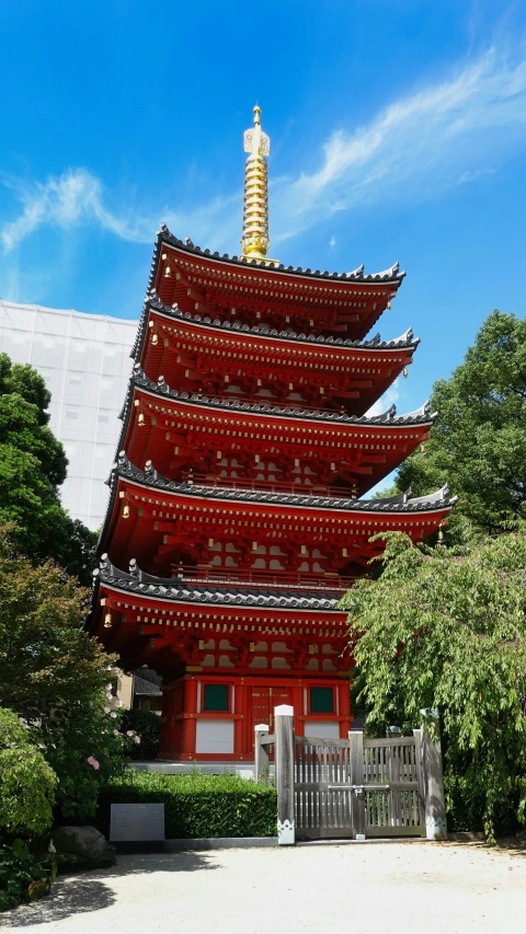 a tall pagoda is behind a gate