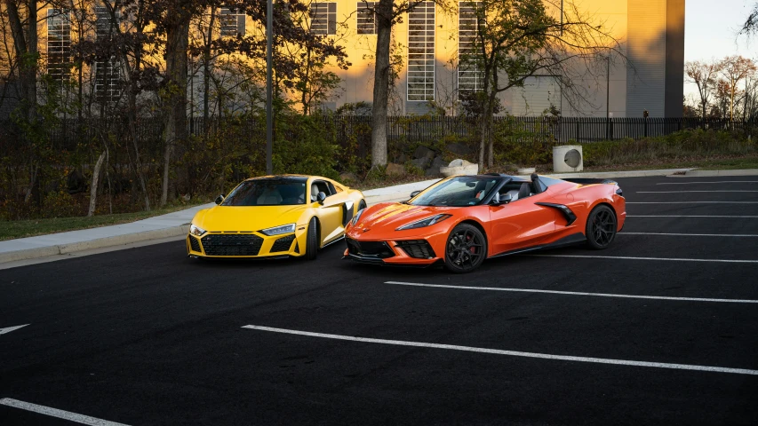 two cars parked in parking lot with buildings behind them