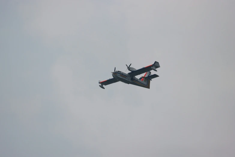 an airplane flying in the sky with a gray sky background