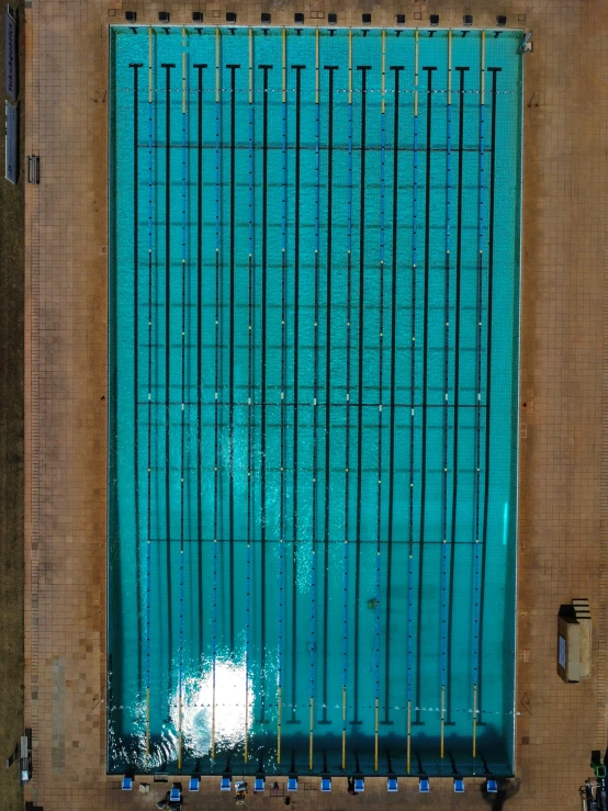 a tall blue and brown wall next to a swimming pool