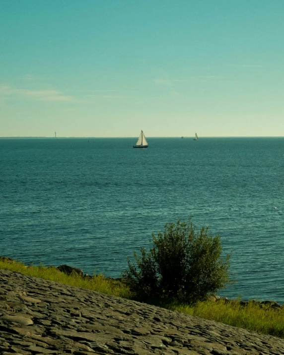 a lone sailboat in the middle of an ocean