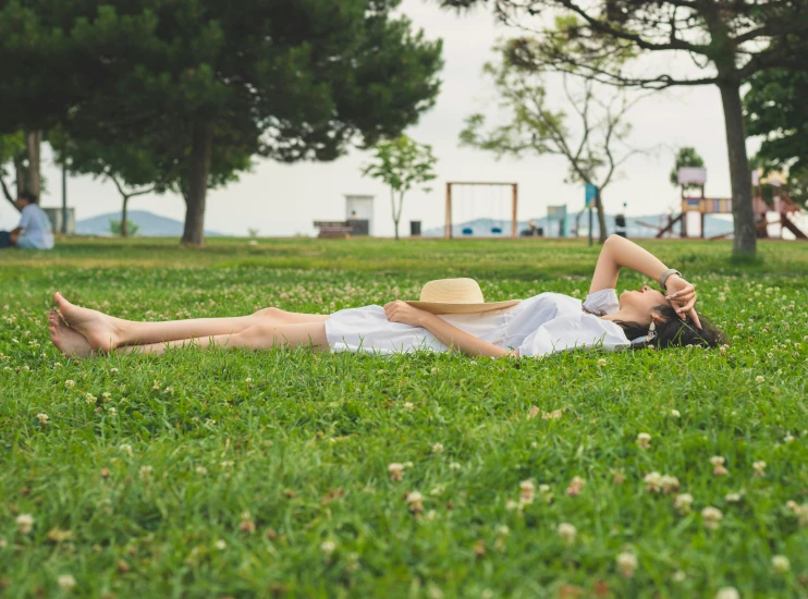 a person laying in a field and resting on the grass