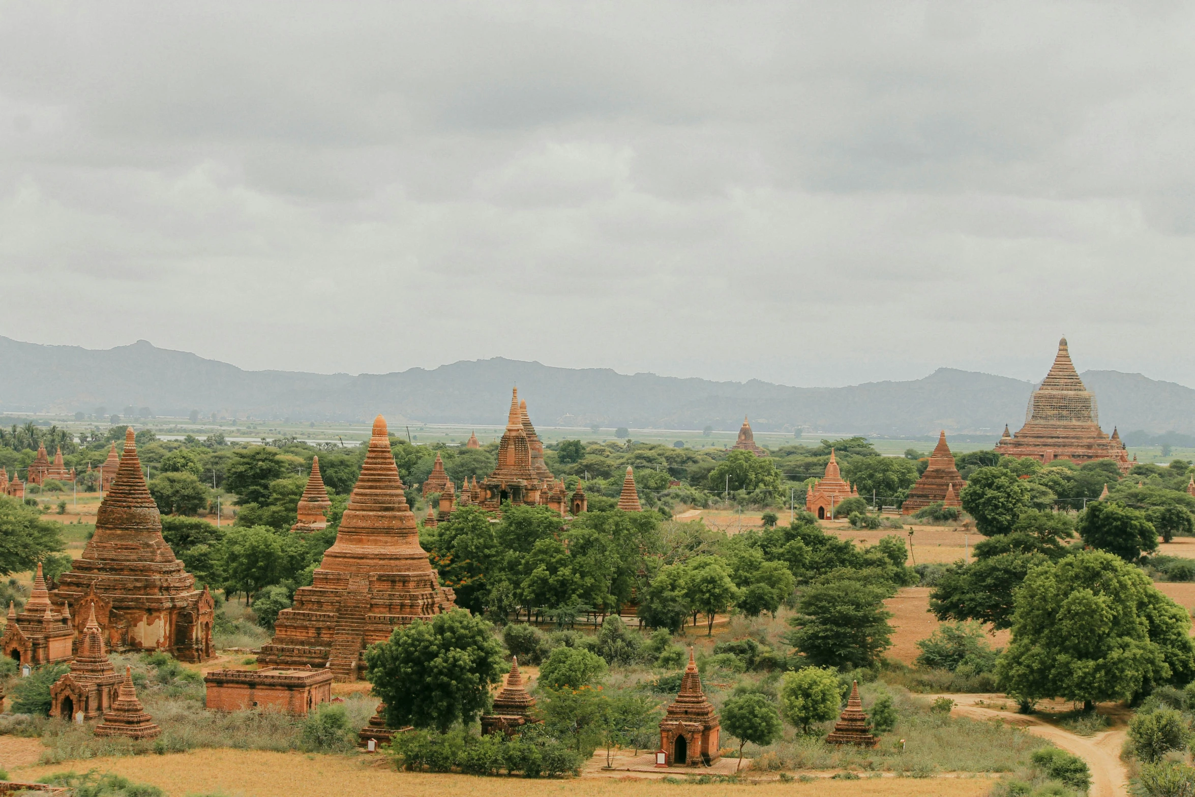 a bunch of large orange buildings in a dirt lot