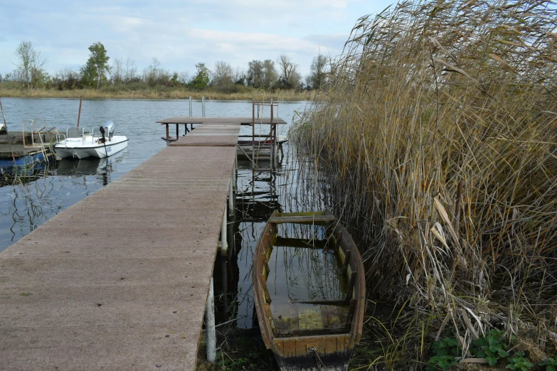 small boats are docked at a wooden pier