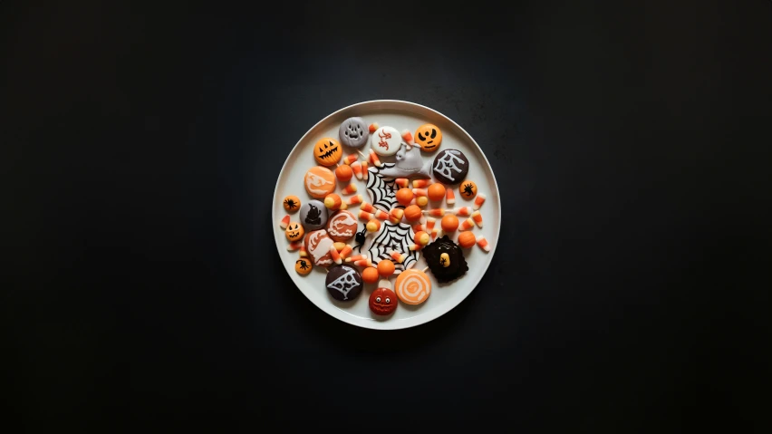 plate with halloween themed candies on black surface