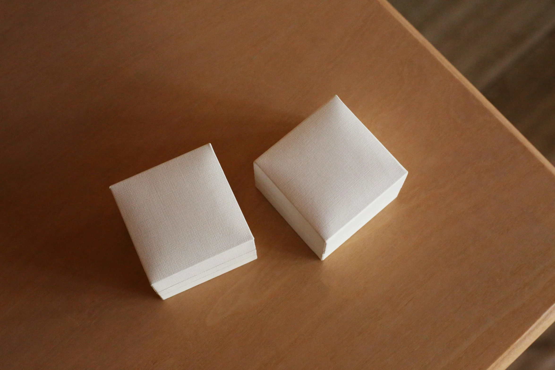 two square papers sit atop the brown surface